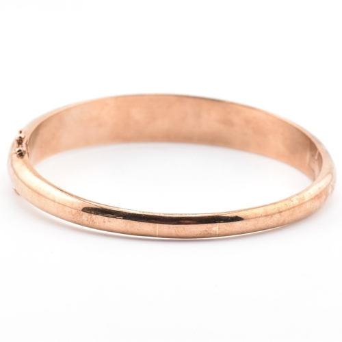 49a - A hallmarked 9ct rose gold sapphire, diamond gem set bombe bangle. The hinged bangle set with diamon... 