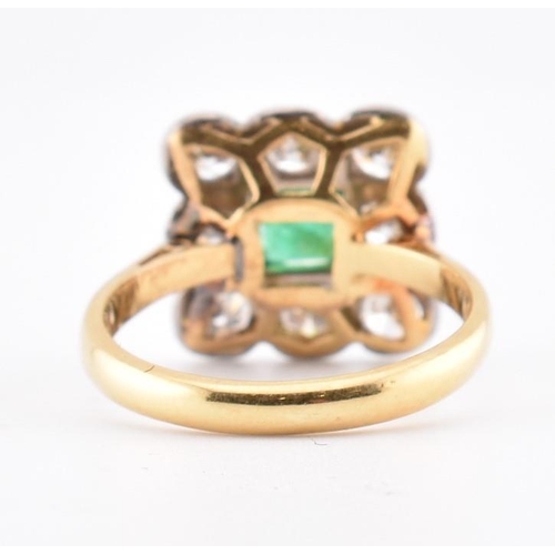 5 - An 18ct gold and platinum, emerald and diamond cluster ring. The 18ct yellow gold ring having a cent... 