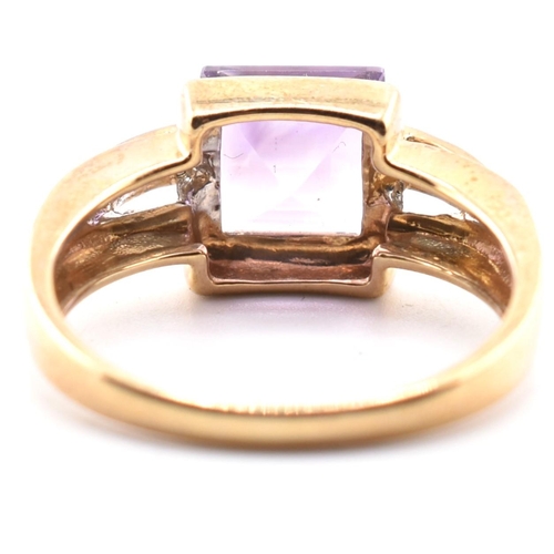 513 - A hallmarked 9ct gold amethyst and diamond ring. The ring set with a central step-cut amethyst to di... 