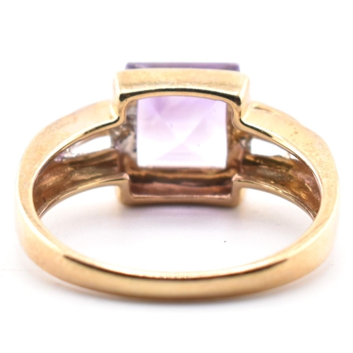 513 - A hallmarked 9ct gold amethyst and diamond ring. The ring set with a central step-cut amethyst to di... 