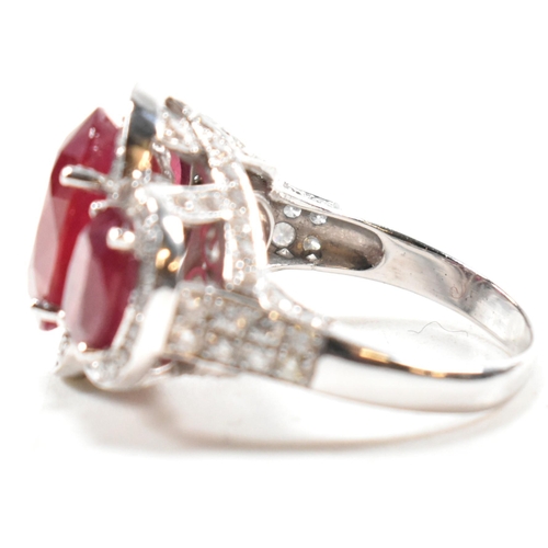 51a - An impressive 18ct white gold three stone ruby and diamond ring. The ring set with three graduating ... 