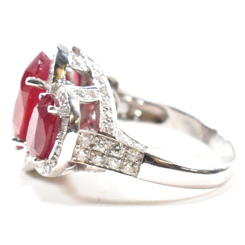 51a - An impressive 18ct white gold three stone ruby and diamond ring. The ring set with three graduating ... 