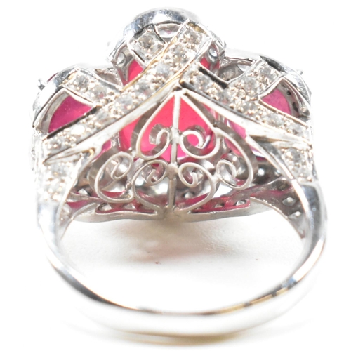 51a - An impressive 18ct white gold three stone ruby and diamond ring. The ring set with three graduating ... 