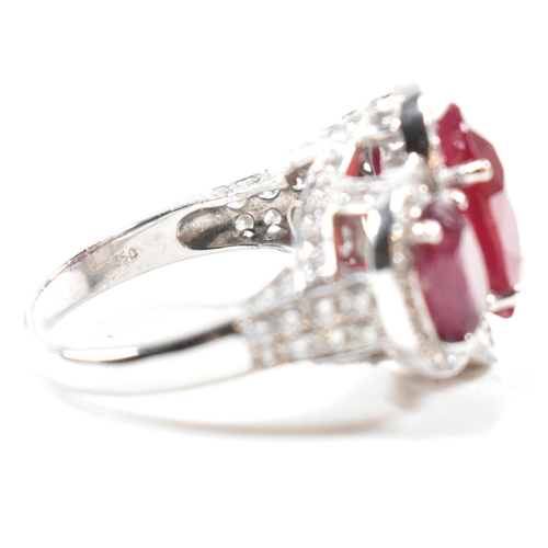 51a - An impressive 18ct white gold three stone ruby and diamond ring. The ring set with three graduating ... 