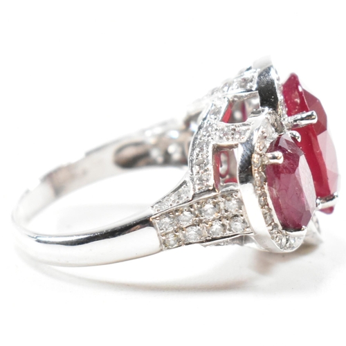 51a - An impressive 18ct white gold three stone ruby and diamond ring. The ring set with three graduating ... 