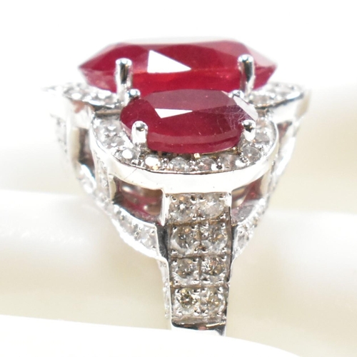 51a - An impressive 18ct white gold three stone ruby and diamond ring. The ring set with three graduating ... 