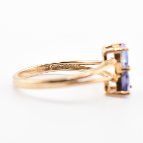 53 - A hallmarked 9ct tanzanite and diamond crossover ring. The 9ct yellow gold ring set with two trillia... 