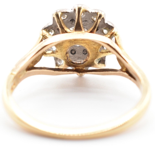 53a - A hallmarked 18 ct gold and diamond flower cluster ring. The ring set with a central round brilliant... 