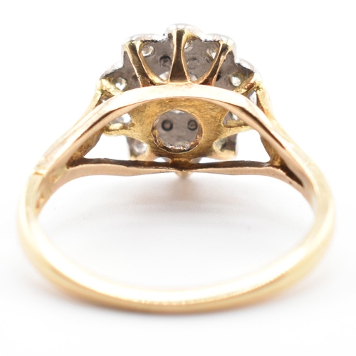 53a - A hallmarked 18 ct gold and diamond flower cluster ring. The ring set with a central round brilliant... 