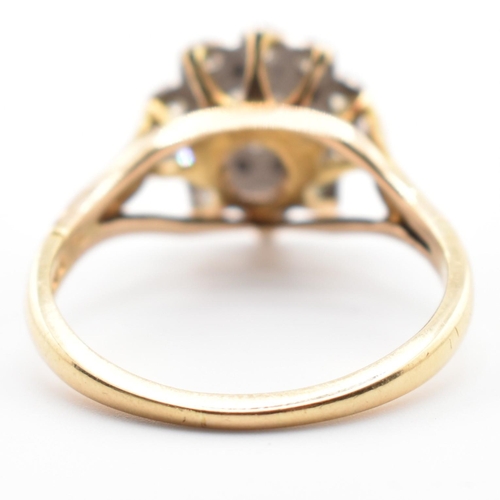 53a - A hallmarked 18 ct gold and diamond flower cluster ring. The ring set with a central round brilliant... 