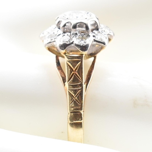 53a - A hallmarked 18 ct gold and diamond flower cluster ring. The ring set with a central round brilliant... 