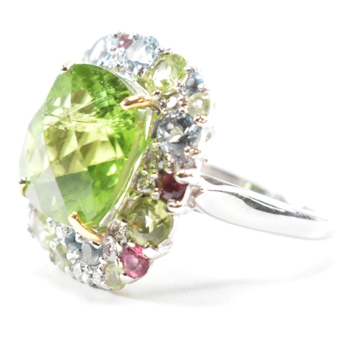 56a - A hallmarked 18ct gold peridot and gem set cluster ring. The ring set with a cushion cut peridot fra... 