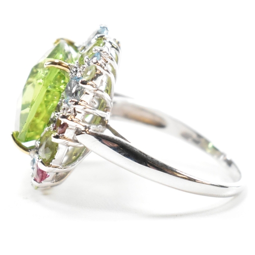 56a - A hallmarked 18ct gold peridot and gem set cluster ring. The ring set with a cushion cut peridot fra... 