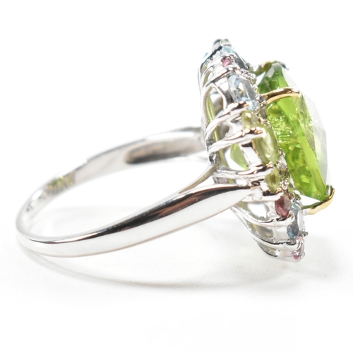 56a - A hallmarked 18ct gold peridot and gem set cluster ring. The ring set with a cushion cut peridot fra... 