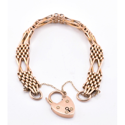 57 - A 9ct rose gold gate link bracelet with heart padlock clasp. The 9ct rose gold gate link bracelet ha... 