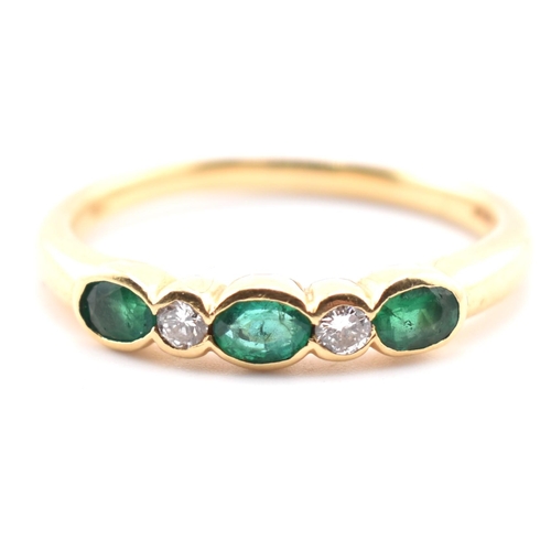 58a - A hallmarked 18ct gold emerald and diamond five-stone ring. The ring having three oval cut emeralds ... 