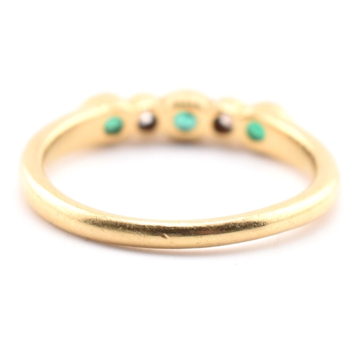 58a - A hallmarked 18ct gold emerald and diamond five-stone ring. The ring having three oval cut emeralds ... 