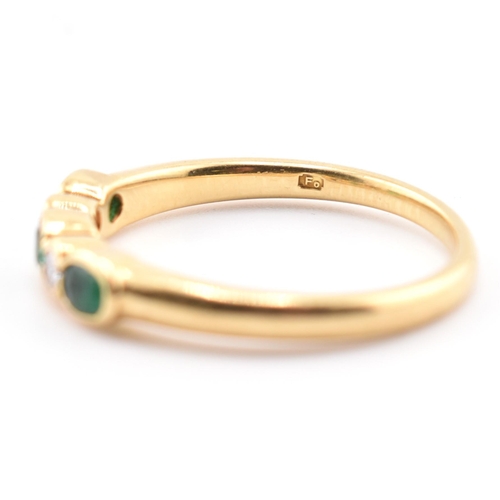 58a - A hallmarked 18ct gold emerald and diamond five-stone ring. The ring having three oval cut emeralds ... 