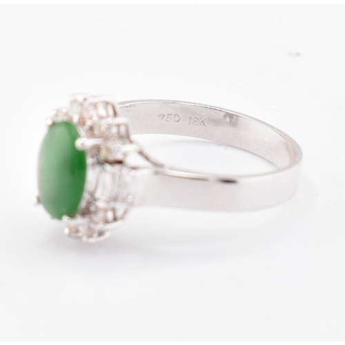 60 - An 18ct white gold jade and diamond halo ring. The 18ct white gold ring set with a central oval jade... 