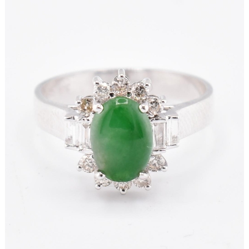 60 - An 18ct white gold jade and diamond halo ring. The 18ct white gold ring set with a central oval jade... 