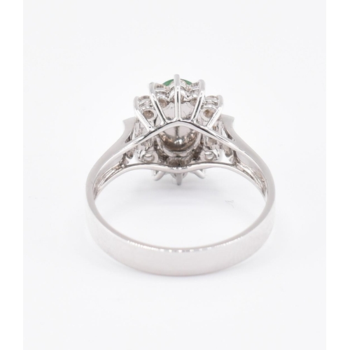 60 - An 18ct white gold jade and diamond halo ring. The 18ct white gold ring set with a central oval jade... 