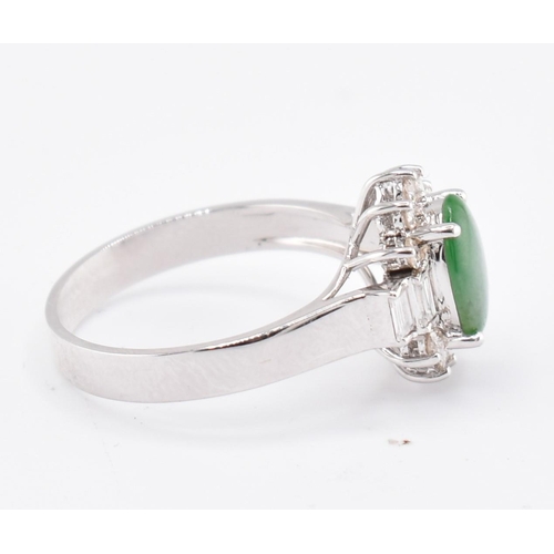 60 - An 18ct white gold jade and diamond halo ring. The 18ct white gold ring set with a central oval jade... 