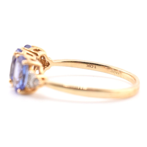 63 - A hallmarked 9ct gold tanzanite and diamond ring. The 9ct yellow gold ring set with three oval cut t... 