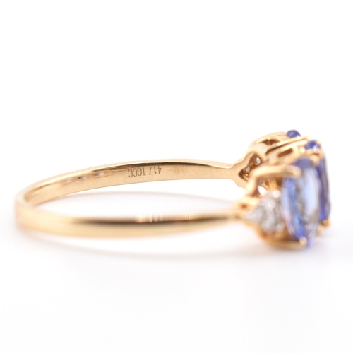 63 - A hallmarked 9ct gold tanzanite and diamond ring. The 9ct yellow gold ring set with three oval cut t... 