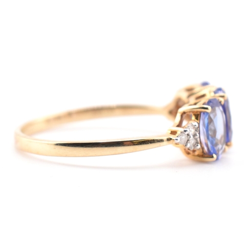 63 - A hallmarked 9ct gold tanzanite and diamond ring. The 9ct yellow gold ring set with three oval cut t... 