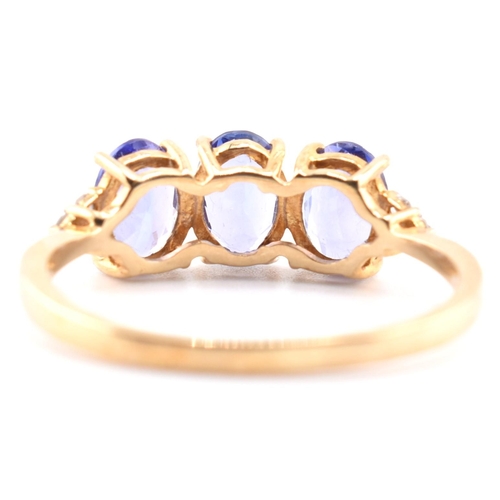 63 - A hallmarked 9ct gold tanzanite and diamond ring. The 9ct yellow gold ring set with three oval cut t... 