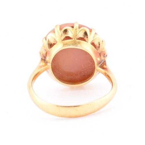 67 - A gold and agate ring. The ring having a claw set round agate cabochon to tapered shoulders and poli... 