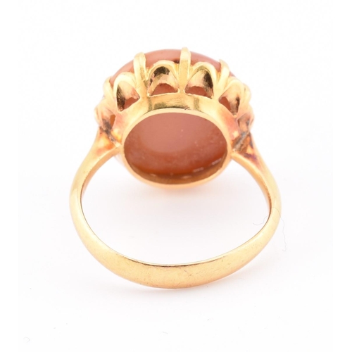 67 - A gold and agate ring. The ring having a claw set round agate cabochon to tapered shoulders and poli... 