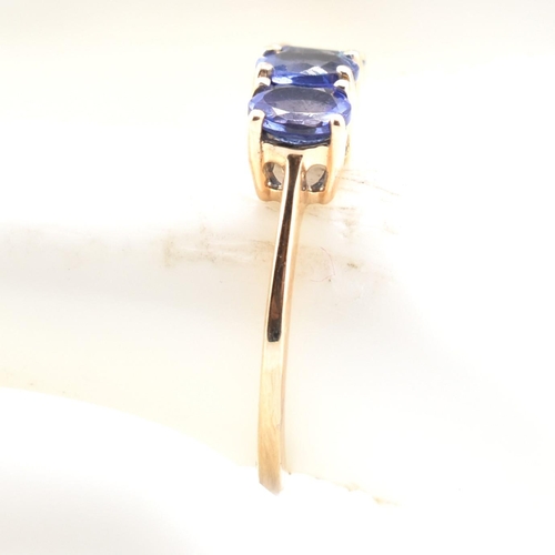 68 - A hallmarked 9ct gold and tanzanite three stone ring. The ring set with three four-prong set oval cu... 