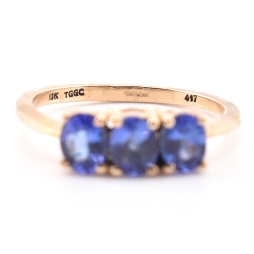 68 - A hallmarked 9ct gold and tanzanite three stone ring. The ring set with three four-prong set oval cu... 