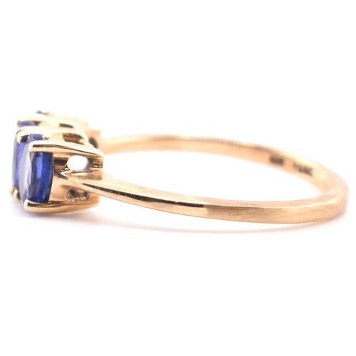 68 - A hallmarked 9ct gold and tanzanite three stone ring. The ring set with three four-prong set oval cu... 