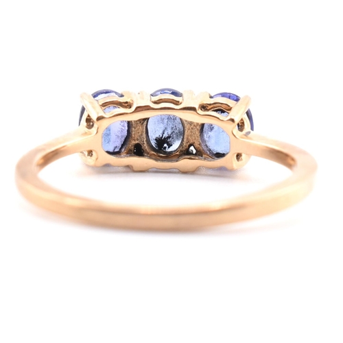 68 - A hallmarked 9ct gold and tanzanite three stone ring. The ring set with three four-prong set oval cu... 