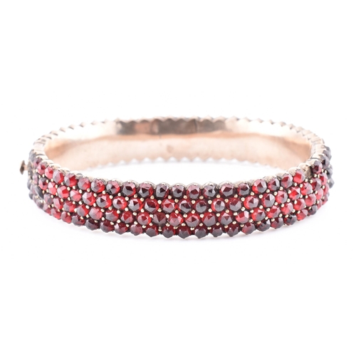 74 - A collection of Bohemian garnet jewellery. The lot to include a garnet set hinged bangle with concea... 