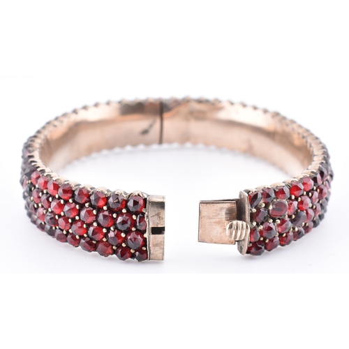 74 - A collection of Bohemian garnet jewellery. The lot to include a garnet set hinged bangle with concea... 