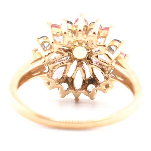 78 - A hallmarked 9ct gold, sapphire and tourmaline flower cluster ring. The 9ct yellow gold ring having ... 