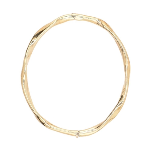 79 - A hallmarked 9ct gold hinged bangle cased. The 9ct yellow gold bangle having a twisted design with h... 