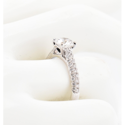 8 - An 18ct gold and diamond solitaire ring. The 18ct white gold solitaire ring set with a central four ... 