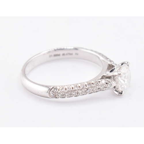 8 - An 18ct gold and diamond solitaire ring. The 18ct white gold solitaire ring set with a central four ... 