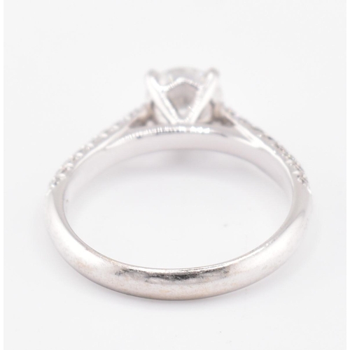 8 - An 18ct gold and diamond solitaire ring. The 18ct white gold solitaire ring set with a central four ... 