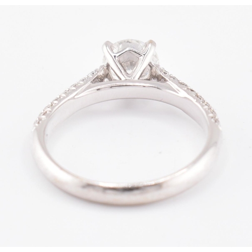 8 - An 18ct gold and diamond solitaire ring. The 18ct white gold solitaire ring set with a central four ... 