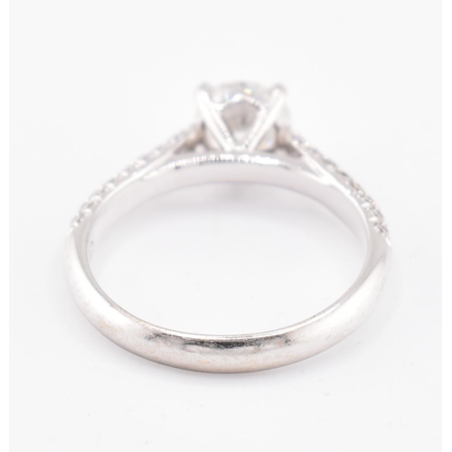 8 - An 18ct gold and diamond solitaire ring. The 18ct white gold solitaire ring set with a central four ... 