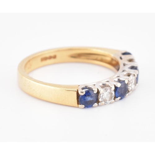 85 - A hallmarked 18ct gold, sapphire and diamond half hoop ring. The 18ct yellow gold ring set with a si... 