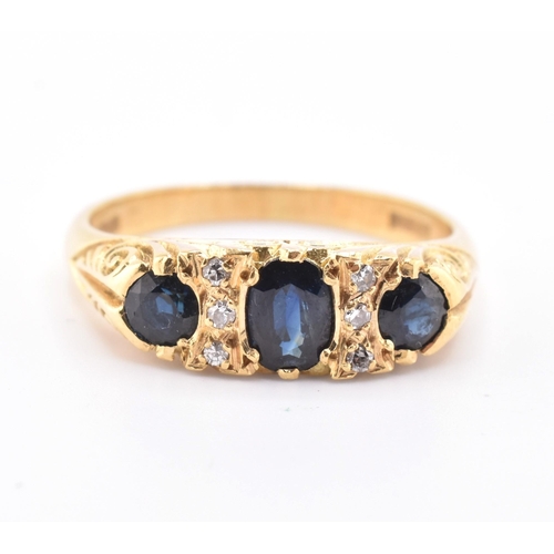 86 - A hallmarked 18ct gold sapphire and diamond three stone gypsy ring. The 18ct yellow gold ring having... 