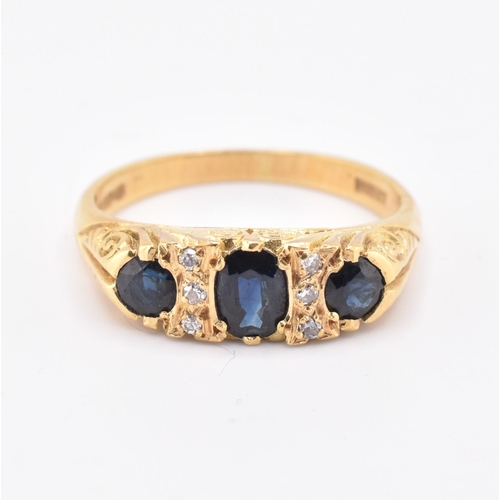 86 - A hallmarked 18ct gold sapphire and diamond three stone gypsy ring. The 18ct yellow gold ring having... 