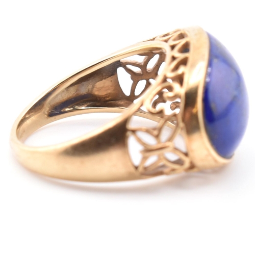 88 - A hallmarked 9ct gold and lapis lazuli dome ring. The 9ct yellow gold ring having an oval lapis lazu... 