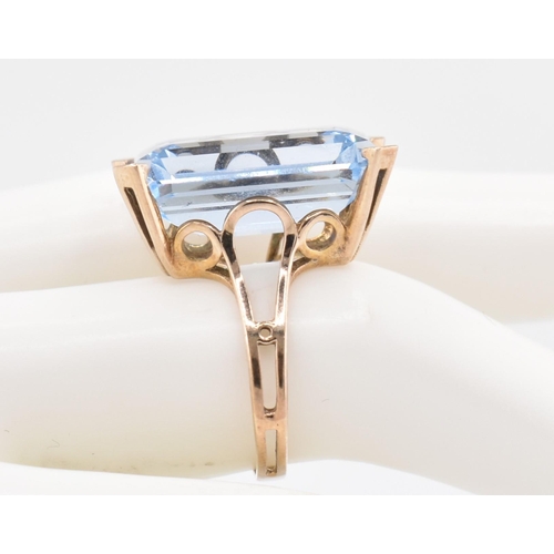 91 - A gold and synthetic spinel ring. The gold ring set with a single emerald cut synthetic spinel set i... 